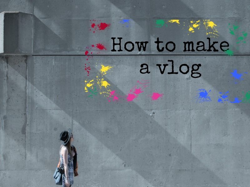 Woman looking at a wall that reads "how to make a vlog" - How to start a vlog: Everything you need to know - Image